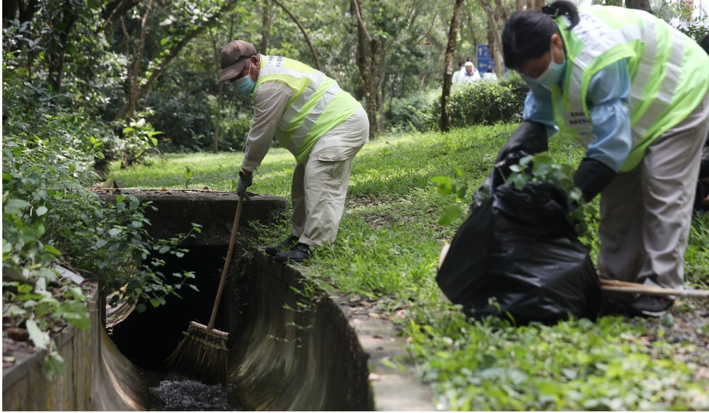 Workers from the Food and Environmental Hygiene Department clear drains in Po Lam to ensure there is no stagnant water for mosquitoes to breed. Photo: Xiaomei Chen