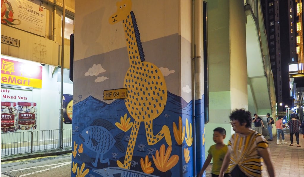 A painted giraffe and walking fish add a splash of colour to a wall in Tai Hang. Photo: Martin Chan
