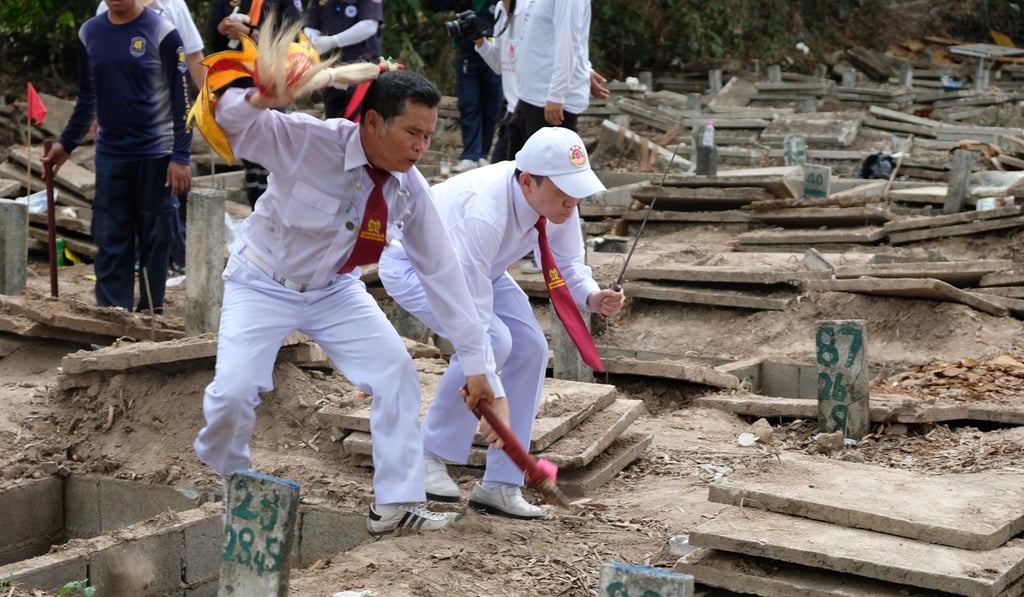 Thanakorn Theerakarunwong (right), a Thai-Chinese spirit medium, is pinpointing a grave whose occupant will need to be exhumed during a ceremony at a boneyard in Pattaya. Photo: Tibor Krausz