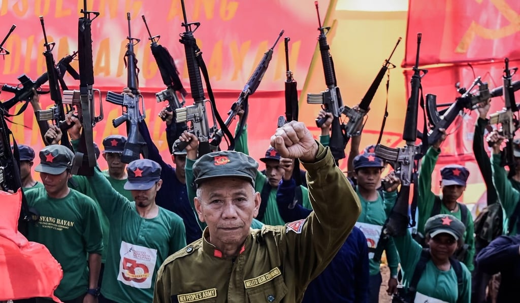 Jaime ‘Ka Diego’ Padilla (centre), spokesman for the Melito Glor Command of the New People’s Army raises his fist along side his comrades during their 50th founding anniversary celebration in the mountains of Sierra Madre, Philippines in March 2019. Photo: EPA