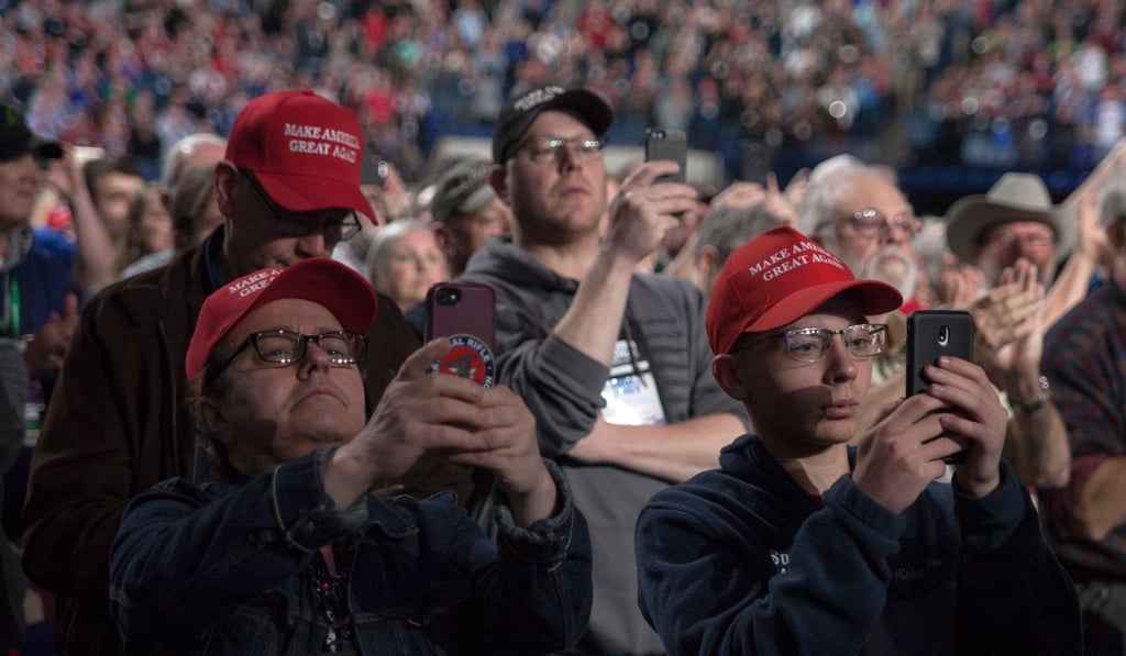 Supporters take pictures and video with their phones as US President Donald Trump makes his entrance at the National Rifle Association Annual Meeting on Friday. Photo: AFP Supporters take pictures and video with their phones as US President Donald Trump makes his entrance at the National Rifle Association Annual Meeting on Friday. Photo: AFP