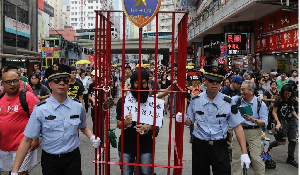 Protesters dress as mainland Chinese police officers, complete with a fugitive. Photo: K.Y. Cheng