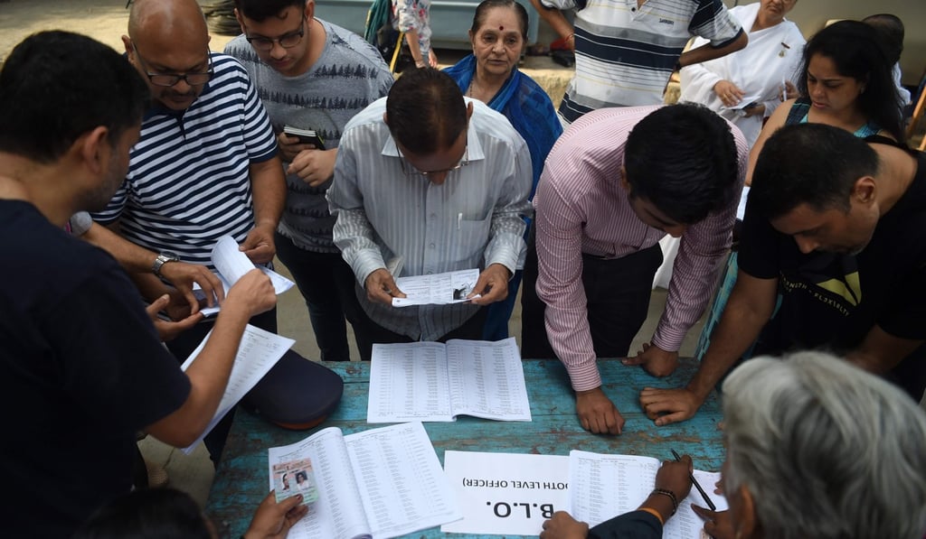 Indian residents check their names in voters list before casting their votes at a polling station during the fourth phase of general election in Mumbai on April 29, 2019. Photo: AFP