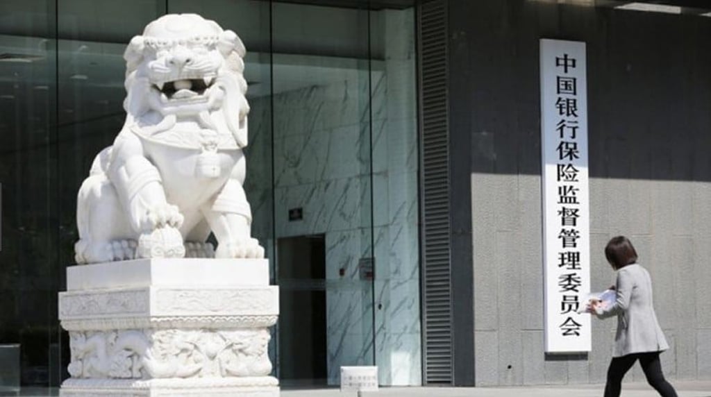 A pedestrian walks past the headquarters of China Banking and Insurance Regulatory Commission (CBIRC) in Beijing. Photo: DFIC