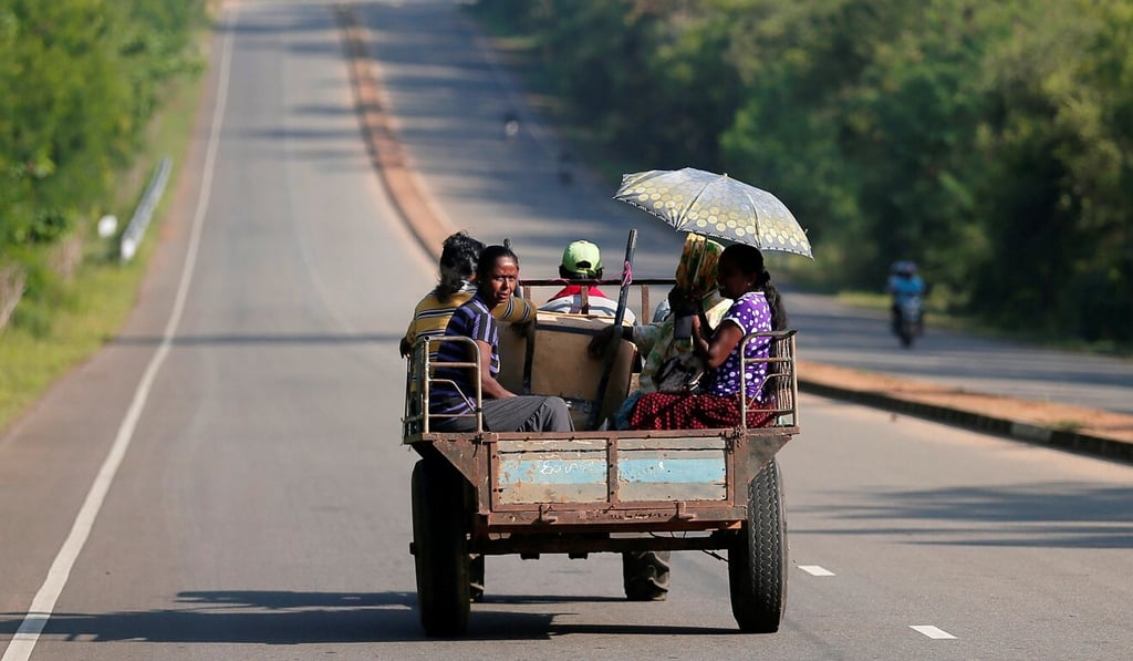 Villagers travel in a tractor on a newly built road in Hambantota, Sri Lanka, on March 24. Photo: Reuters