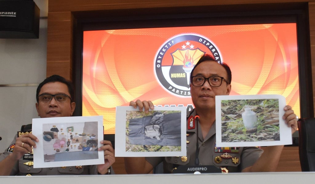 Indonesian police officers show photos of a suspected militant and evidence seized during a press conference in Jakarta on May 6. Photo: AFP