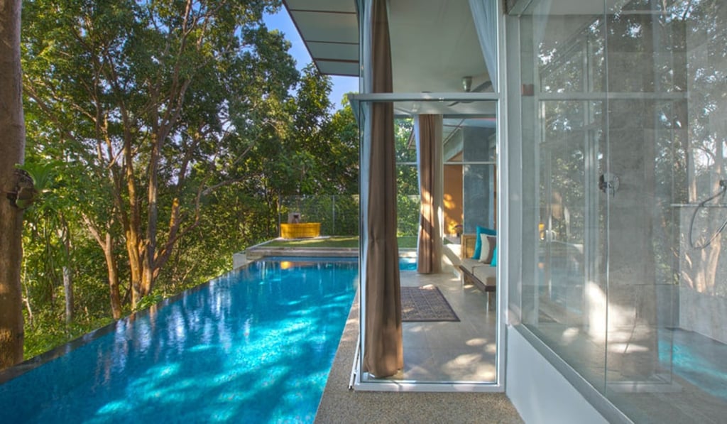 The bedroom doors slide open right beside the infinity pool at Ambong Pool Villas, on the Malaysian island of Langkawi.