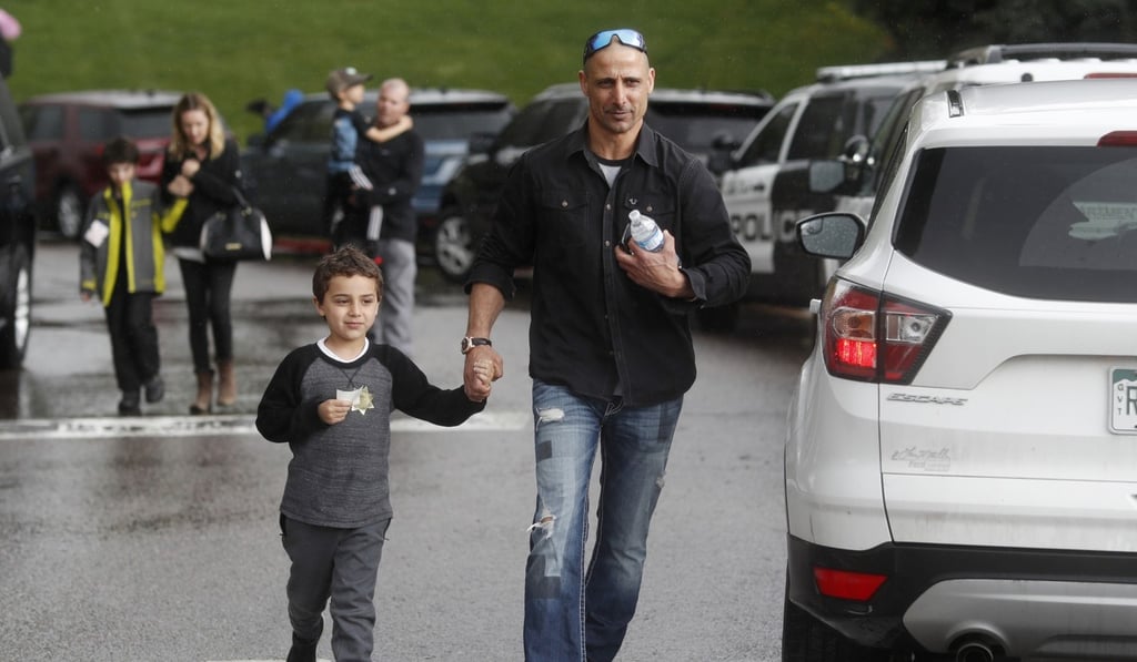 A parent leaves with a child from the recreation centre where students were reunited with their parents after a shooting at a suburban Denver middle school. Photo: AP