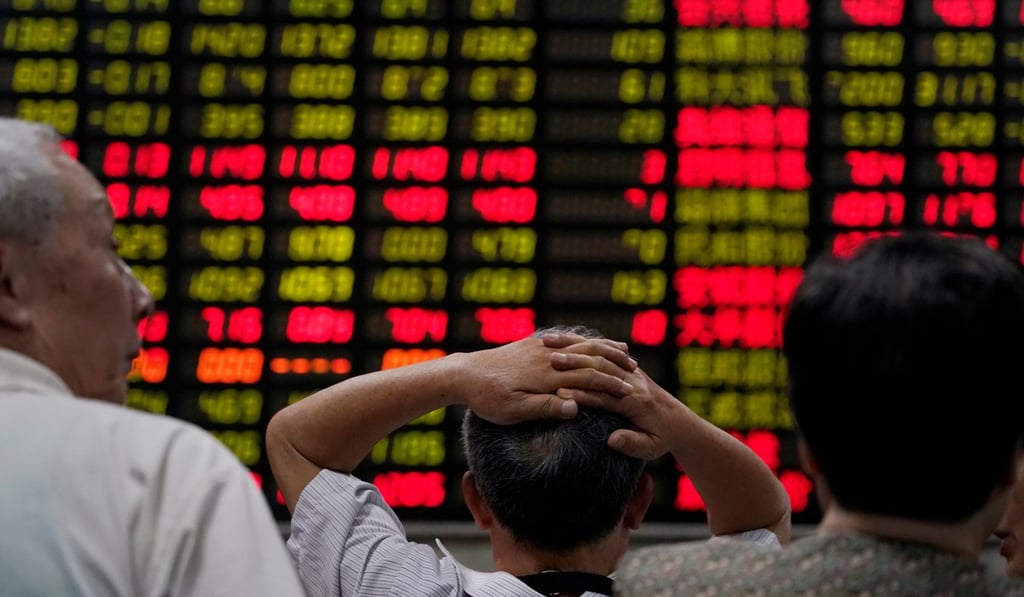 Investors look at an electronic board showing stock information at a brokerage house in Shanghai in June 2018. Photo: Reuters