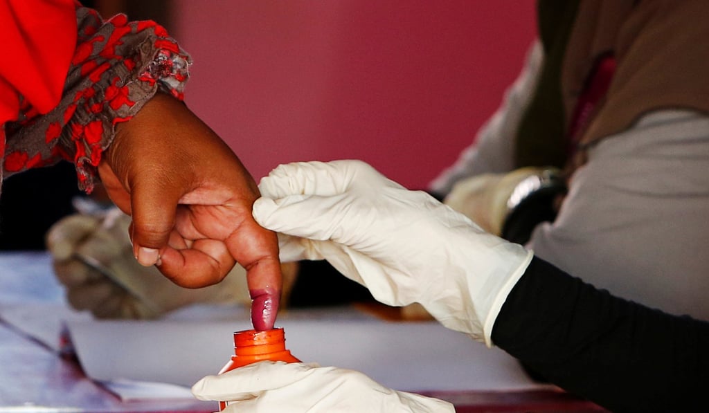 An election worker dips a voter's finger in ink during the general election. Photo: Reuters