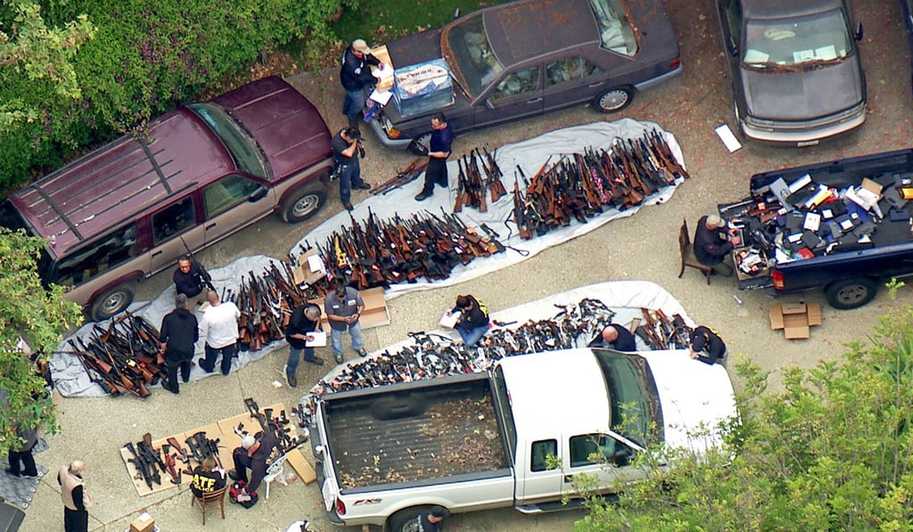 Investigators from the US Bureau of Alcohol, Tobacco, Firearms and Explosives and the police inspecting a large cache of weapons seized at a home in the affluent Holmby Hills area of Los Angeles on Wednesday. Photo: KCBS/KCAL-TV via AP