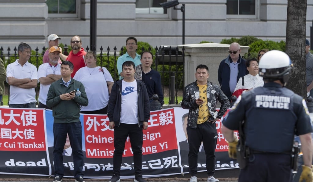 Protesters and onlookers across the street from the site of trade talks between the US and China in Washington, DC, on Friday. Photo: EPA-EFE