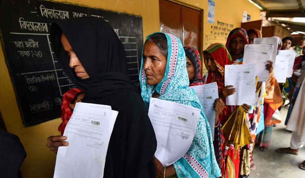 Residents hold their documents as they queue to check their names on the National Register of Citizens in Assam. Photo: AFP