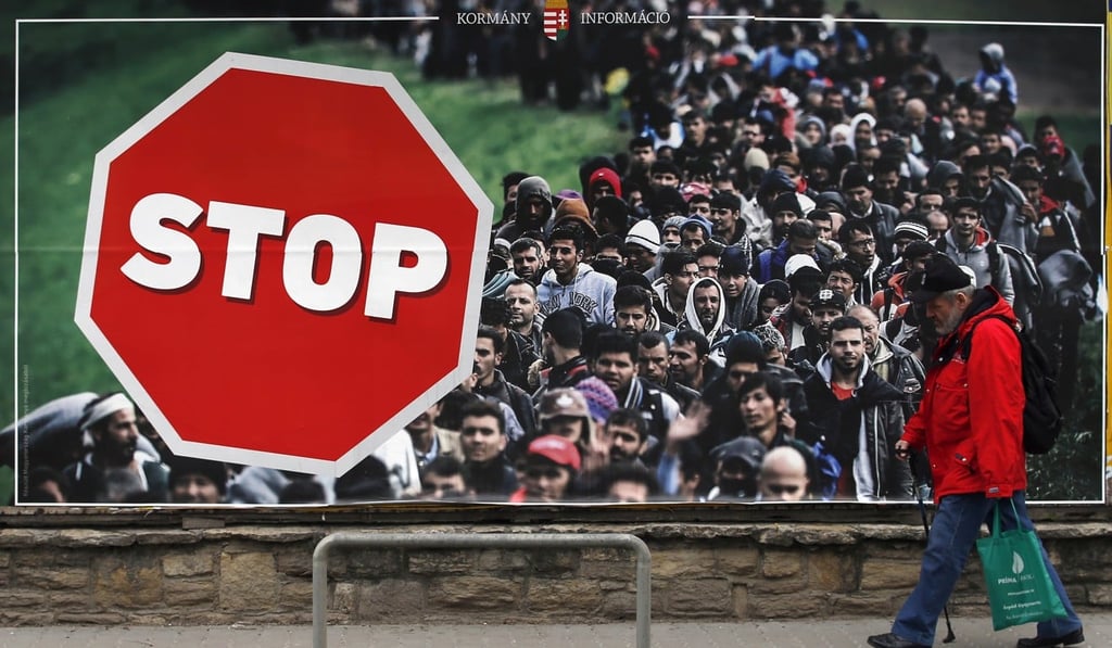 A man walks by an anti-migration billboard from the Hungarian government of Viktor Orban, on a street in Budapest, Hungary. Photo: AP