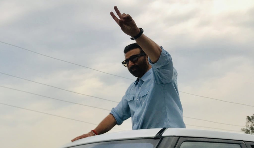 Deol waves to voters from the sunroof of a car in Gurdaspur. Photo: Sonia Sarkar