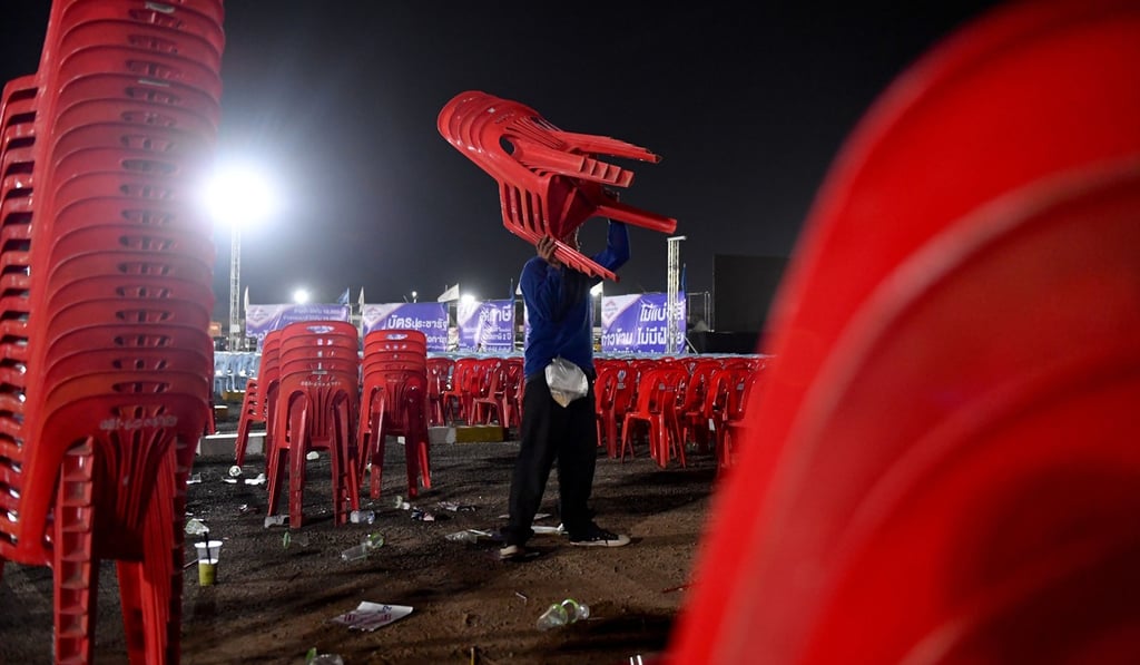 A man stacks chairs after a Palang Pracharath Party rally in the northeastern Thai province of Nakhon Ratchasima in March. Photo: AFP