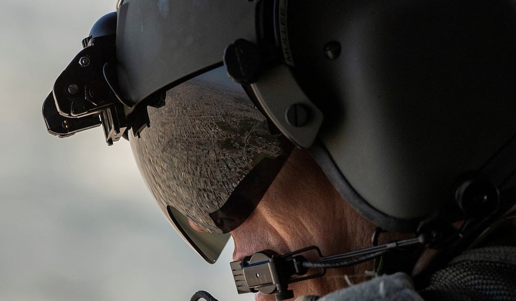 partial view of the Iraqi capital Baghdad is reflected in the visor of a US Army helicopter crew member. Photo: Reuters