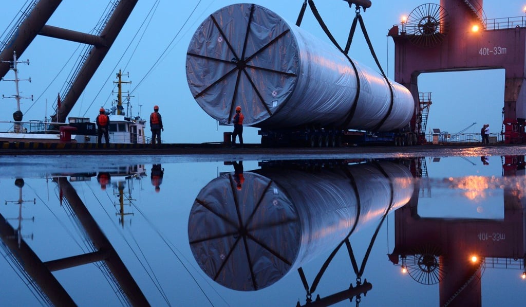 Workers are seen near a crane lifting offshore wind energy equipment, made by the China Construction Industrial and Energy Engineering Group, at a port in Nanjing on April 23. Photo: China Daily via Reuters