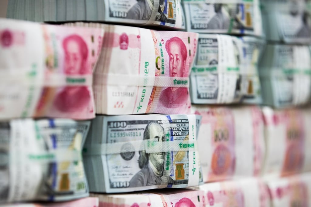 Genuine bundles of Chinese 100 yuan banknotes and US$100 banknotes are arranged for a photograph. Photo: Bloomberg
