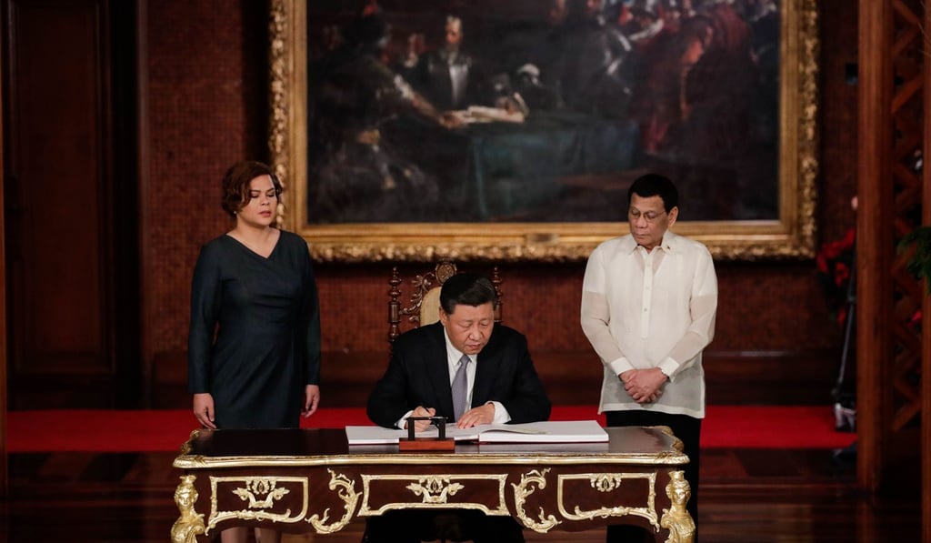 Chinese President Xi Jinping (seated) signs a guest book as Philippine President Rodrigo Duterte and his daughter Sarah look on at the Malacanang Presidential Palace in Manila on November 20, 2018. Photo: AFP