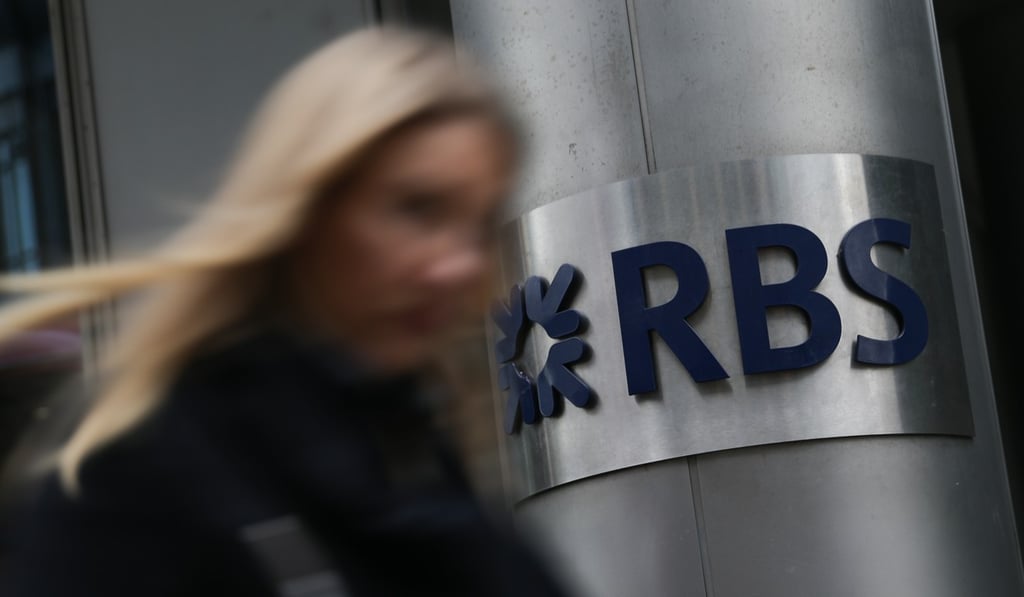 A woman walks past a Royal Bank of Scotland (RBS) sign in central London. Photo: AFP