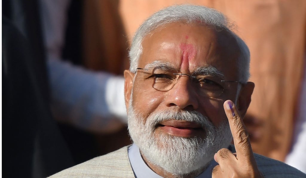 Indian Prime Minister Narendra Modi shows his ink-marked finger after casting his vote. Photo: AFP