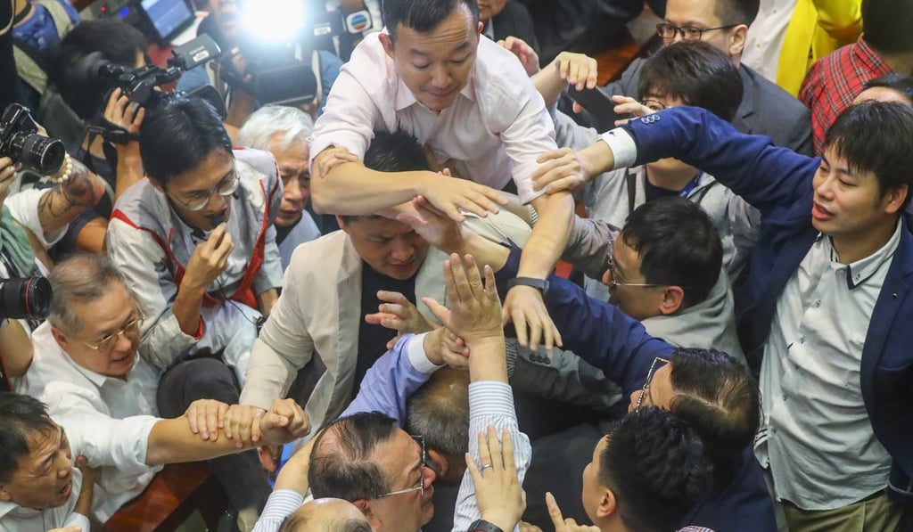 Lawmaker Abraham Razack (bottom centre) is surrounded by other legislators as a scuffle breaks out and the scene descends into chaos. Photo: Edmond So