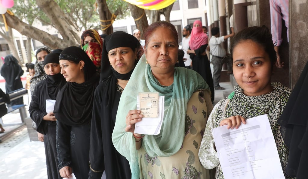 Women voters queue at a polling station in Delhi on Sunday. Photo: EPA
