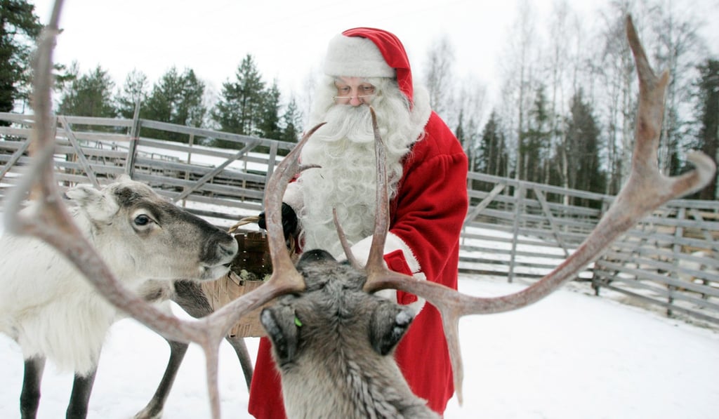 A man dressed as Santa Claus feeds reindeer in preparation for Christmas in Rovaniemi, northern Finland, in December 2007. Photo: Reuters