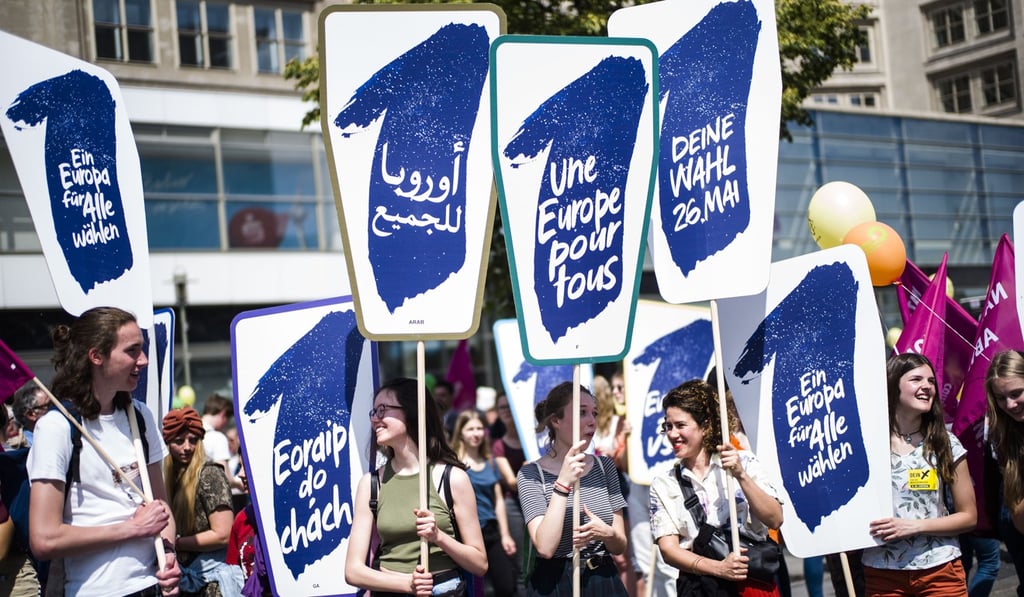 People hold posters as they attend a demonstration in Berlin. Photo: AP Photo People hold posters as they attend a demonstration in Berlin. Photo: AP Photo