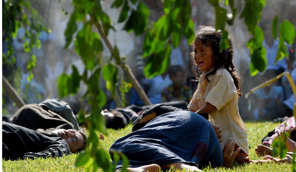 A child cries among those playing dead in a performance to mark the annual 'Day of Anger' at the Choeung Ek killing fields memorial in Phnom Penh. Photo: AFP A child cries among those playing dead in a performance to mark the annual 'Day of Anger' at the Choeung Ek killing fields memorial in Phnom Penh. Photo: AFP