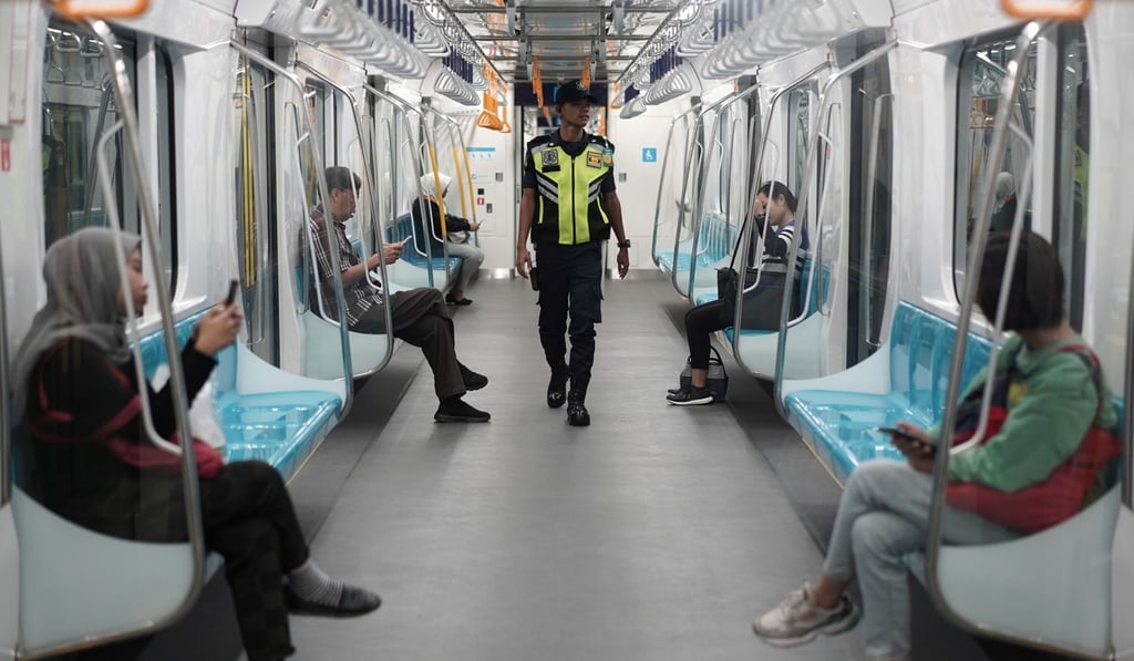 A security official checks a Mass Rapid Transit train carriage on the system’s first day of operation. President Joko Widodo plans to press on with his US$350 billion infrastructure drive. Photo: Bloomberg