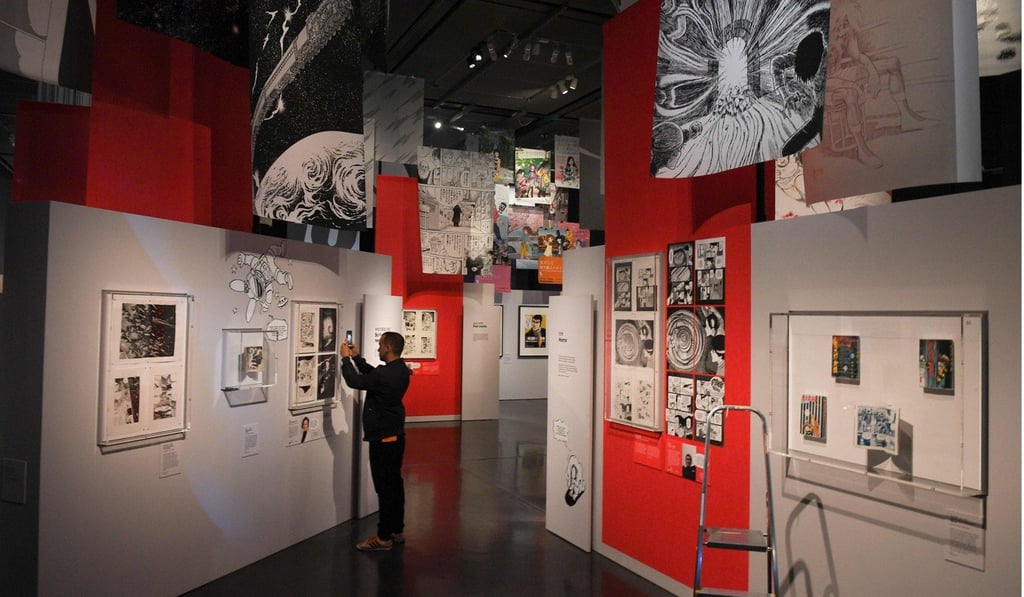 A visitor takes a photograph of a manga comic at the British Museum in central London. Photo: Daniel Leal-Olivas/AFP