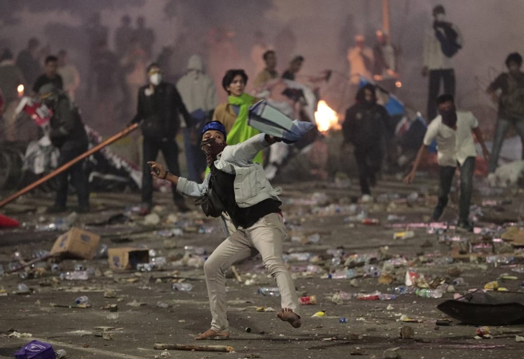 Supporters of Indonesian presidential candidate Prabowo Subianto throw rocks towards riot police on May 22, 2019. Photo: AP