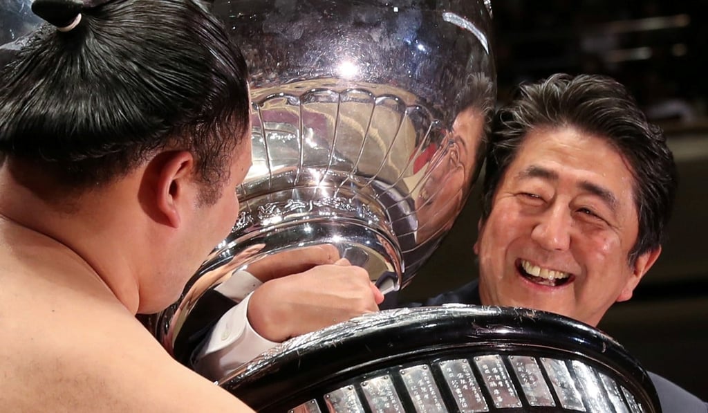 Japanese Prime Minister Shinzo Abe presents the Prime Minister's Cup to wrestler Asanoyama. Photo: Reuters