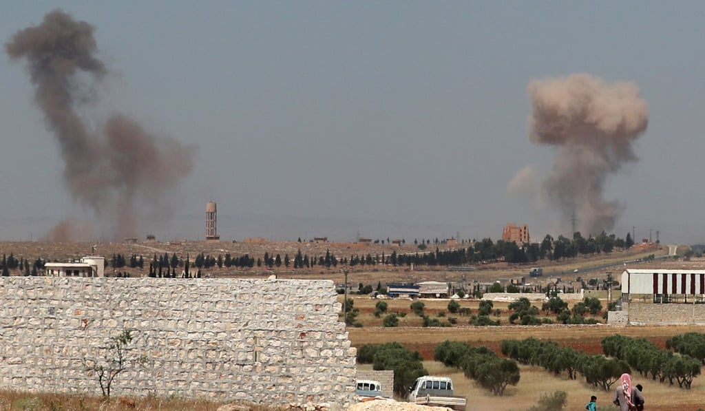 A Syrian man and children watch as smoke billows during reported Syrian government forces’ bombardments in the western countryside of Aleppo province. Photo: AFP A Syrian man and children watch as smoke billows during reported Syrian government forces’ bombardments in the western countryside of Aleppo province. Photo: AFP