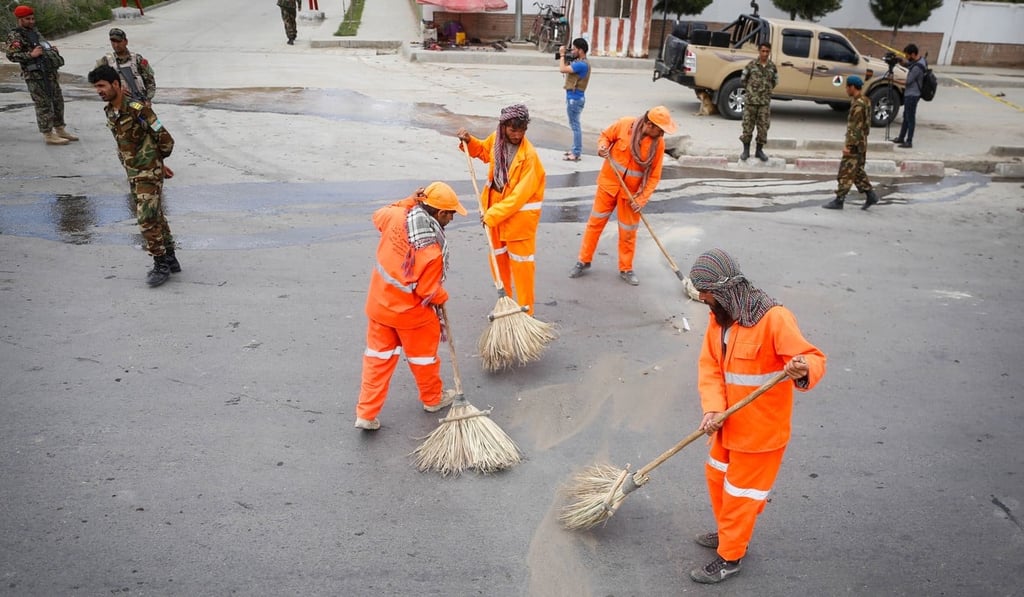 Afghan municipality workers clean the scene of a suicide bomber targeted cadets at Marshal Fahim National Defense University in Kabul. Photo: EPA-EFE