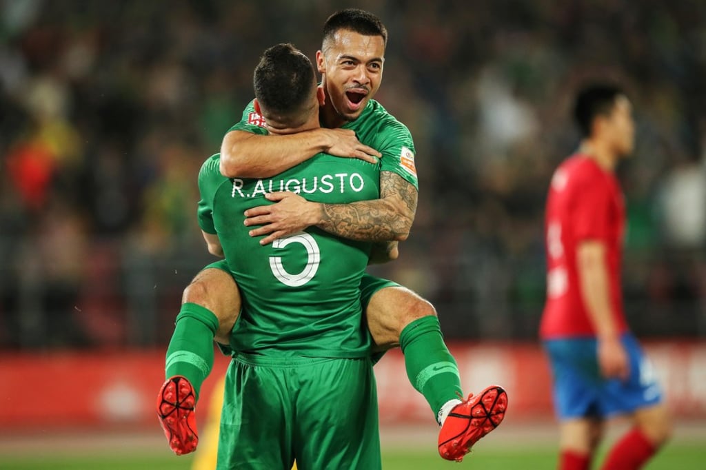 Nico Yennaris (top), also known as Li Ke, celebrates with Beijing Guoan teammate Renato Augusto after scoring during their Chinese Super League match against Henan Jianye. Photo: AFP