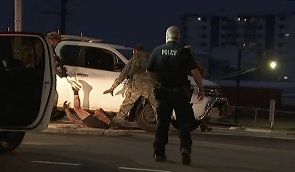 In this still from a video, police apprehend a suspect on the ground next to a white truck in Darwin. Photo: AP