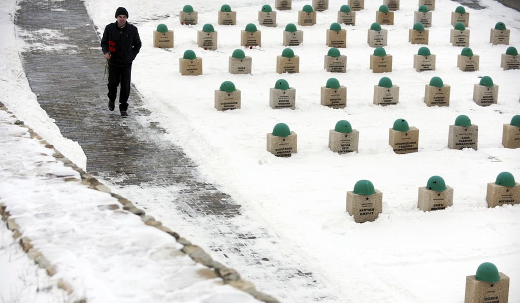 A man carries flowers as he walks past gravestones of the Red Army soldiers who died in the Battle of Stalingrad during the World War II. Photo: AFP