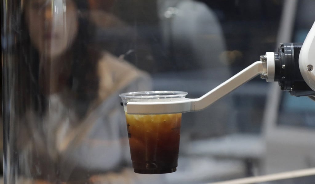 A customer waits for a coffee in front of a robot named b;eat at a cafe in Seoul. Photo: AP