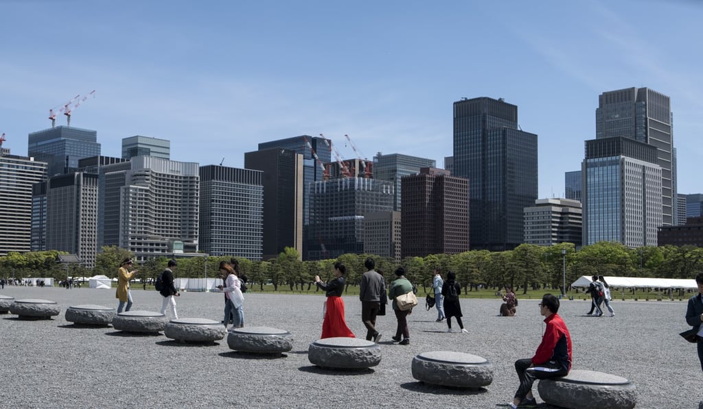 People walk through the outer gardens of the Imperial Palace as buildings stand in the business district in Tokyo. Tokyo is one of the most liquid commercial property markets globally. Photo: Bloomberg