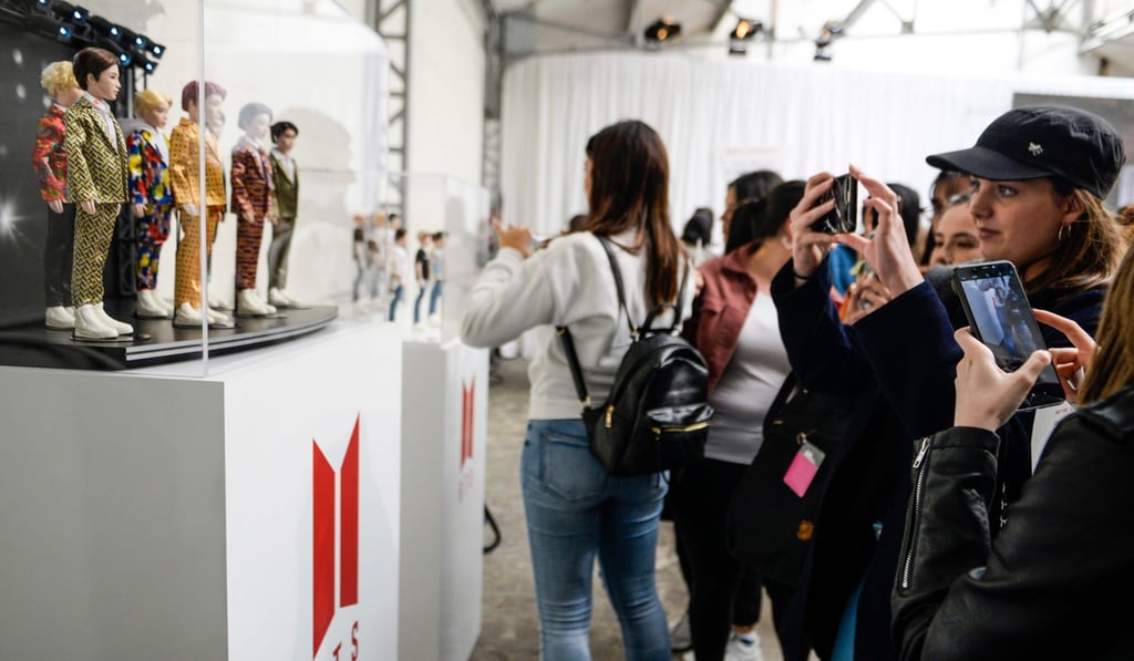 BTS fans take pictures of dolls of band members and other merchandise. Photo: AFP BTS fans take pictures of dolls of band members and other merchandise. Photo: AFP