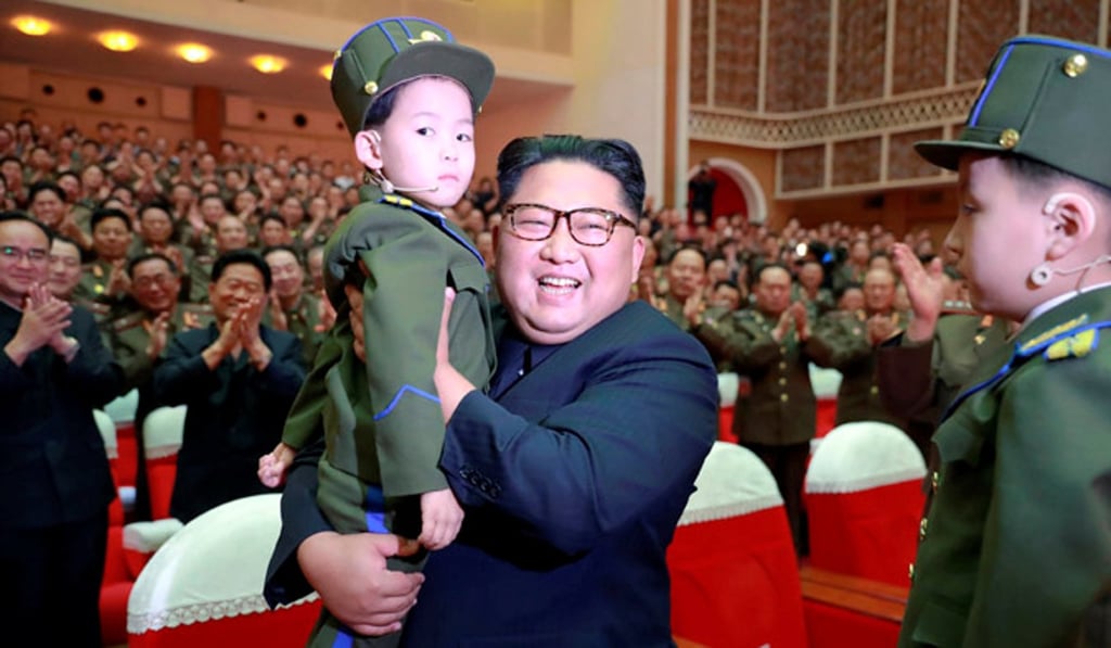 North Korean leader Kim Jong-un holds up a child as he watches a performance in an undated photo released on June 3. Photo: KCNA via Reuters