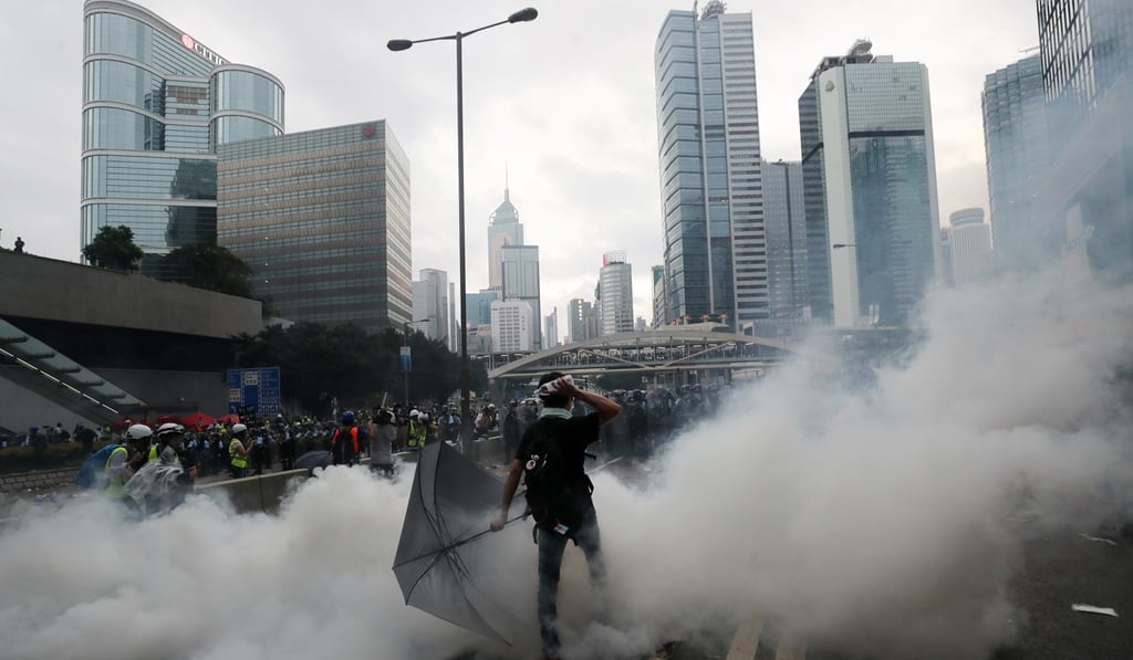 An anti-extradition protester throws an object at police officers on Harcourt Road in Admiralty on Wednesday. Photo: Sam Tsang
