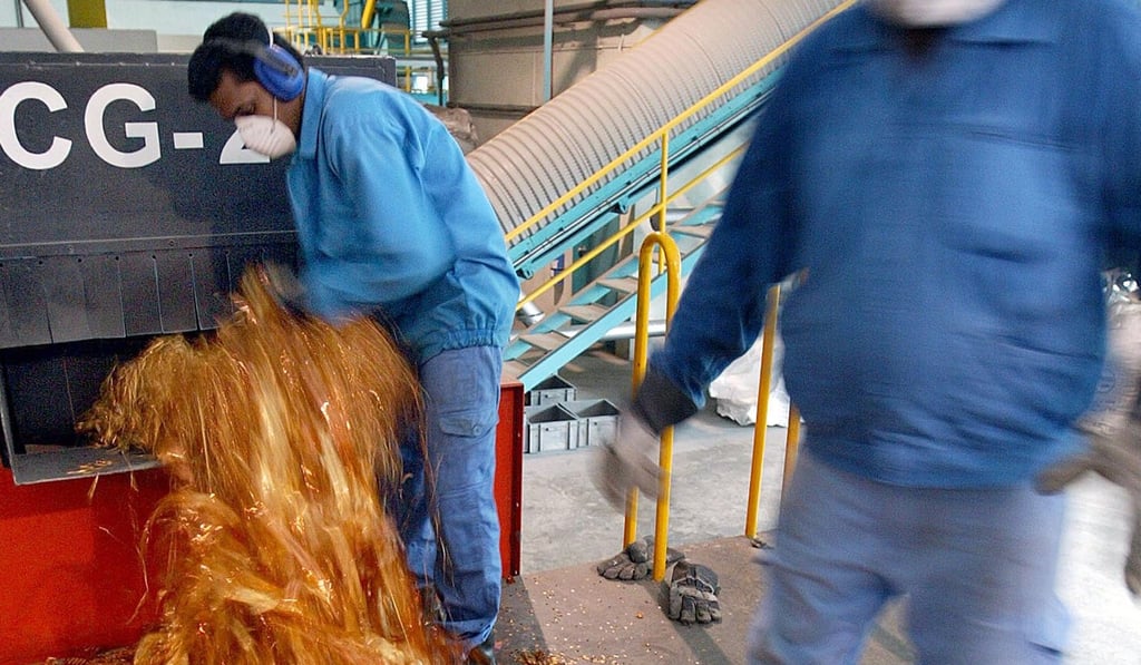 A worker puts gold plated electronics waste into a shredding machine in Singapore, which has declared 2019 the Year of Zero Waste. Photo: AFP