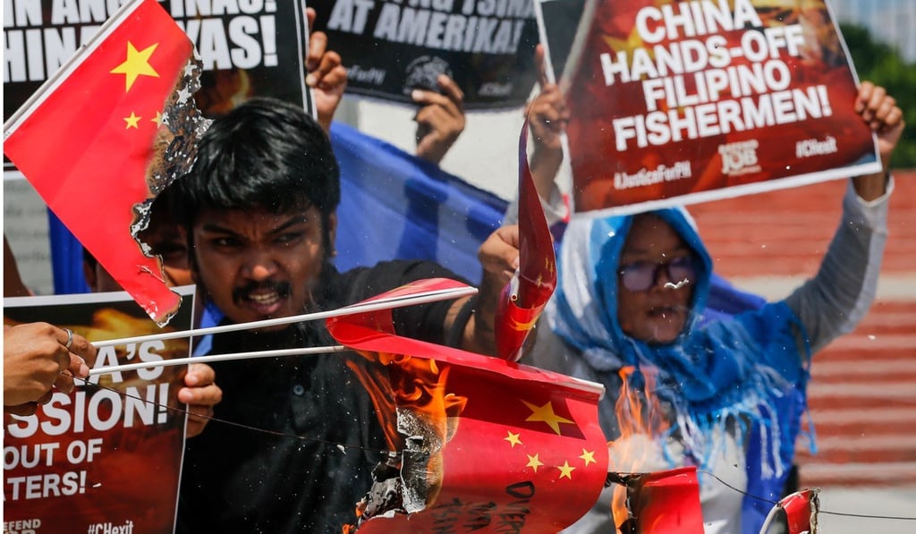 Activists burn paper Chinese flags during a protest in Manila against the sinking. Photo: EPA