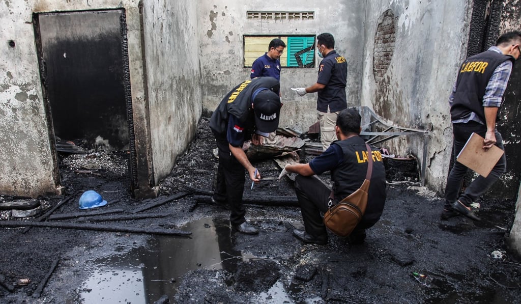 Investigators work at the scene of the burnt-out house in Binjai on June 21. Photo: AFP Investigators work at the scene of the burnt-out house in Binjai on June 21. Photo: AFP
