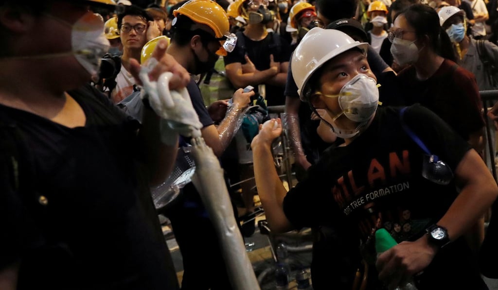 A protester throws an egg into the wall of the police headquarters in Wan Chai. Photo: Reuters