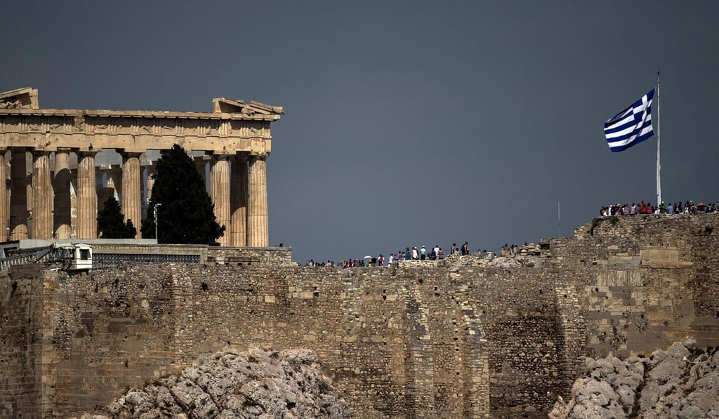 A Greek flag flutters in front of the ancient Parthenon temple atop the Acropolis hill archaeological site in Athens. Photo: Reuters